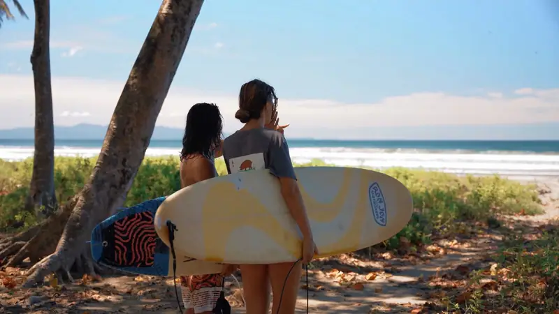Two surfers with their boards facing the ocean